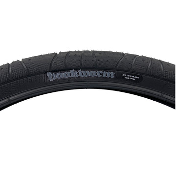A close up of the Maxxis Hookworm 27.5"x2.5 tire.  The Hookworm logo can be seen on the sidewall as well as the size and the max PSI rating of 65